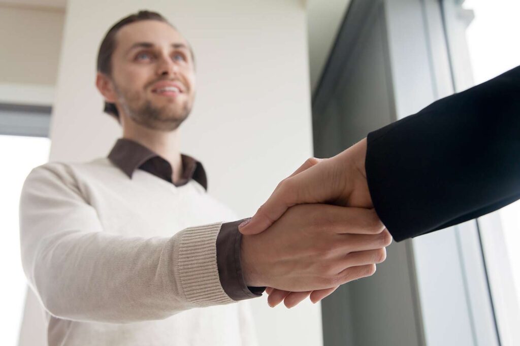 Lawyer shaking clients hand and smiling